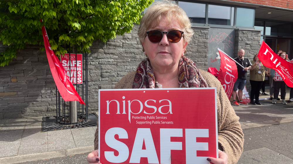 Clare Joudeh holding a strike banner