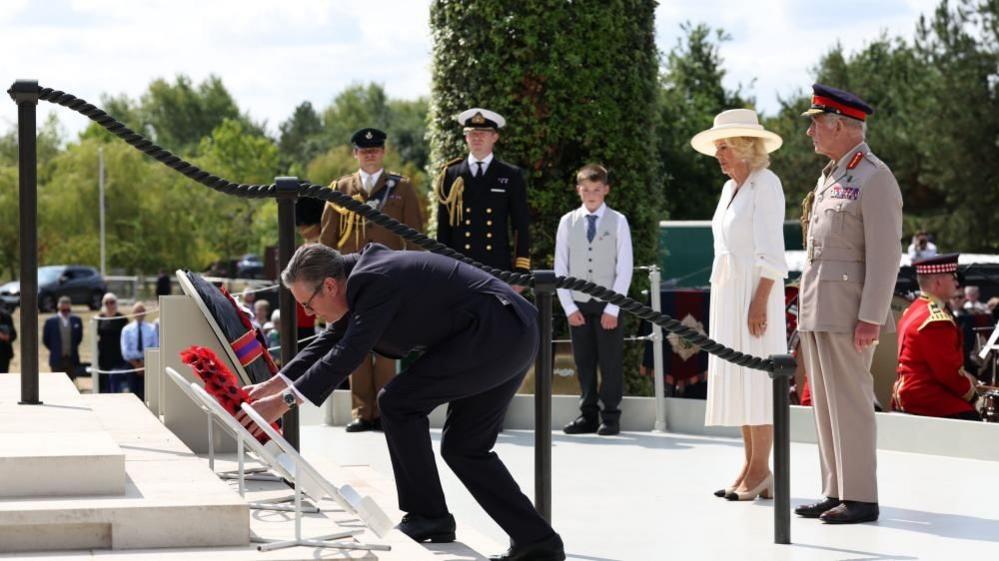 King Charles III (right) and Queen Camilla stand (second right) as Prime Minister Sir Keir Starmer lays a wreath during the national Service of Remembrance to mark the 80th Anniversary of VJ Day at the National Memorial Arboretum in Alrewas, Staffordshire