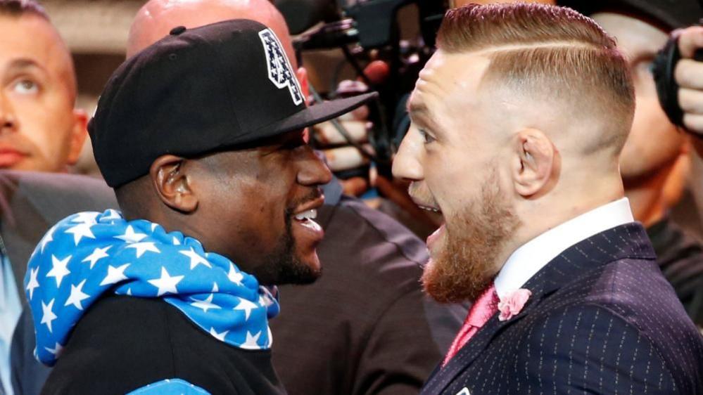 Floyd Mayweather and Conor McGregor smiling in each other's faces