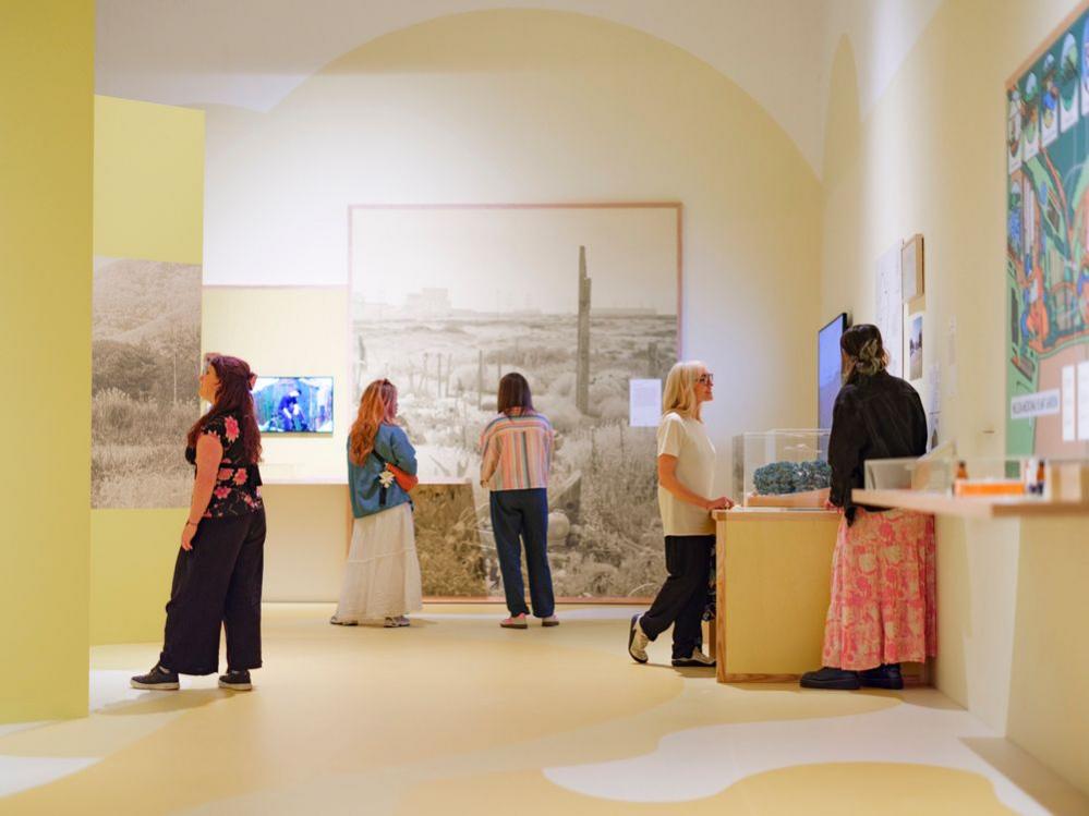 People stand looking at items on display in a gallery