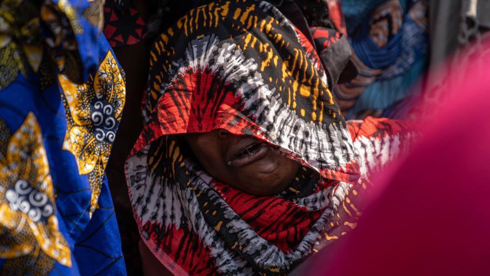 An image of a mourner getting emotional at a burial in the Democratic Republic of Congo on 2 August 2024.