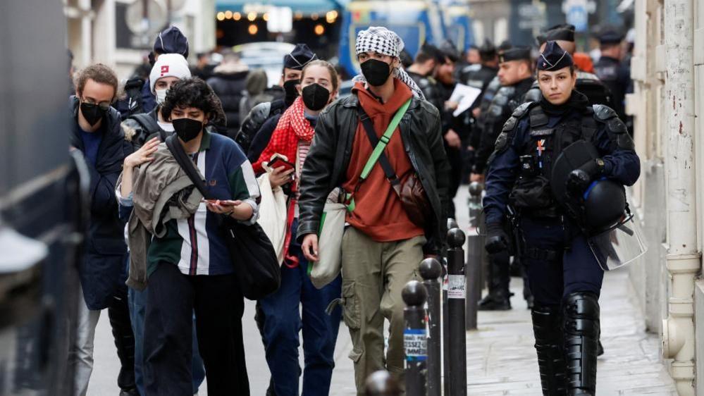 Protesters in support of Palestinians in Gaza are escorted away by police forces during the evacuation of the Sciences Po University in Paris, 3 May 2024