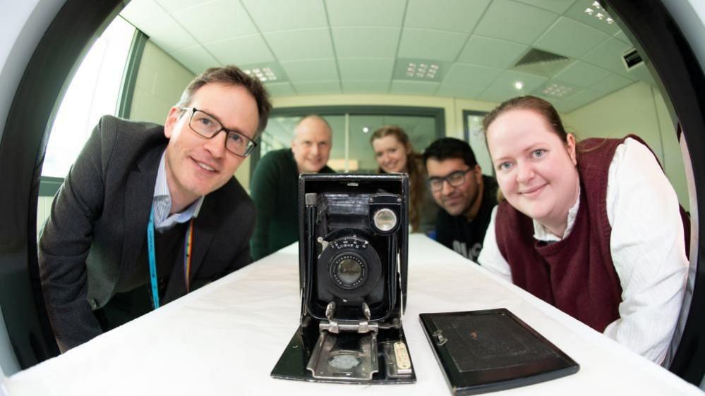 University and museum staff looking at the camera in the scanner