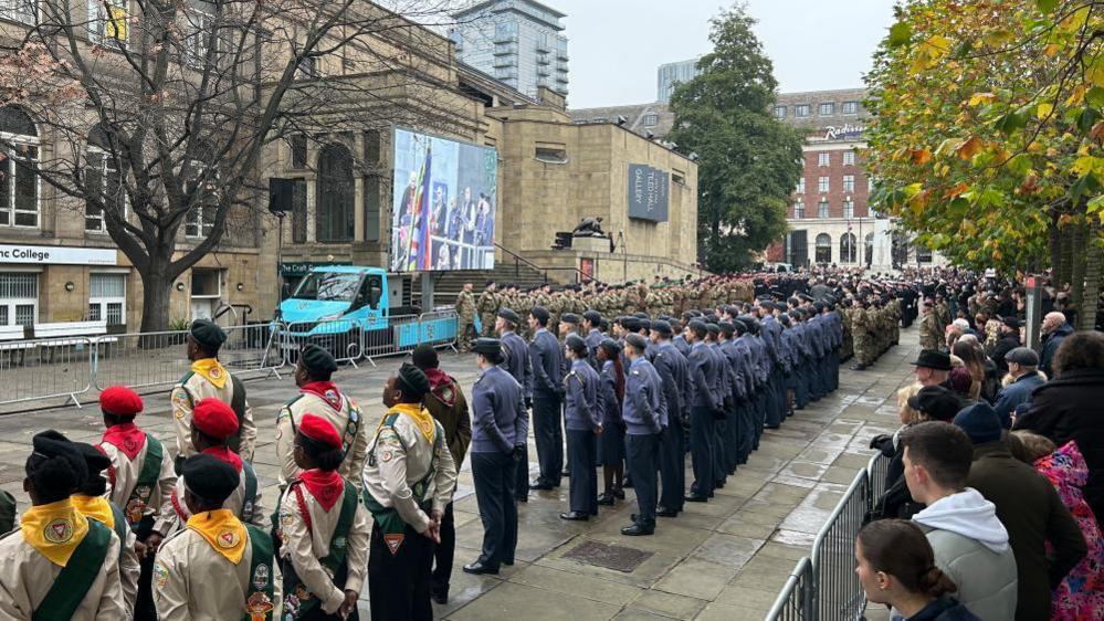 Scouts, Navy and Army personnel stand in lines at a service outside Leeds Civic Hall.