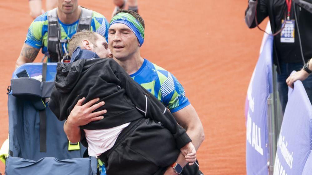 Rob Burrow is carried over the 2023 marathon finish line by his friend and former team-mate Kevin Sinfield