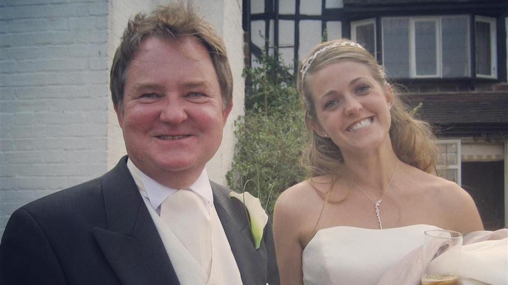 Amy, in her bridal gown, beams next to her father Steve, who wears a tuxedo 