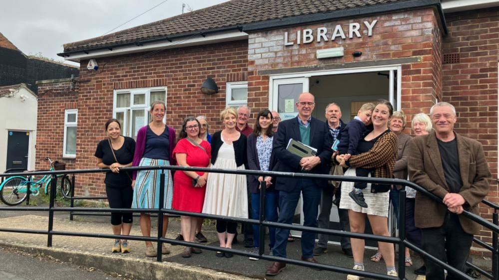 Group of people gather on library steps