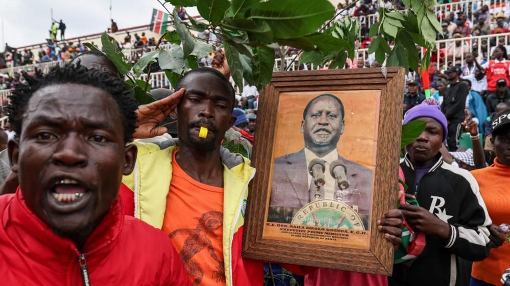 Mourners carrying Odinga's portrait and branches and wrestles 
