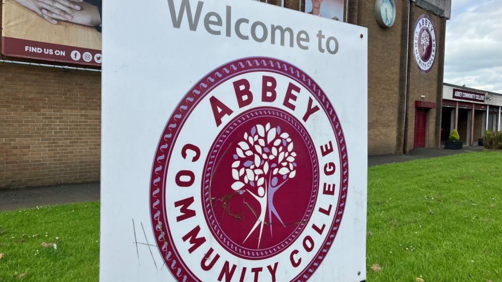 The front of Abbey Community College - a sign in the foreground bears the school logo