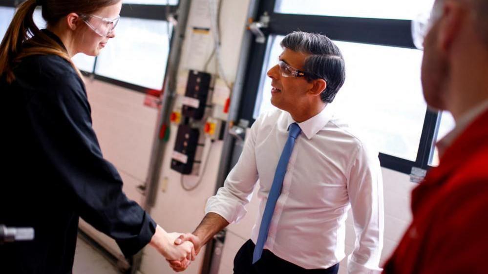 Rishi Sunak shaking hands with a woman