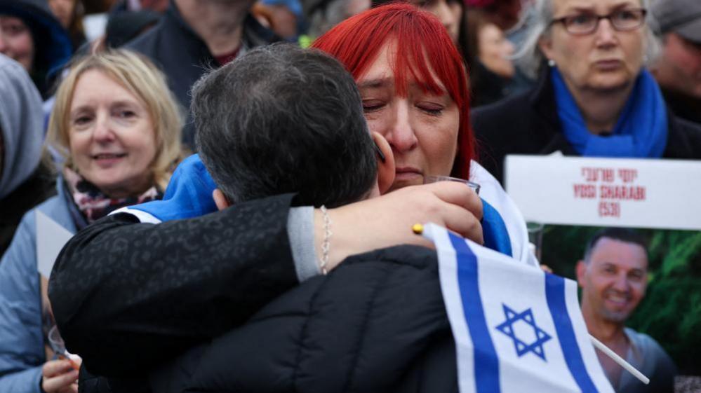 Two people embracing at a memorial event