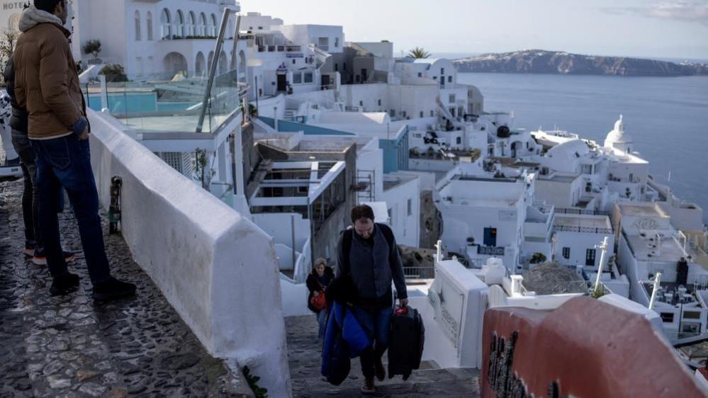 People leaving the Old Port of Fira