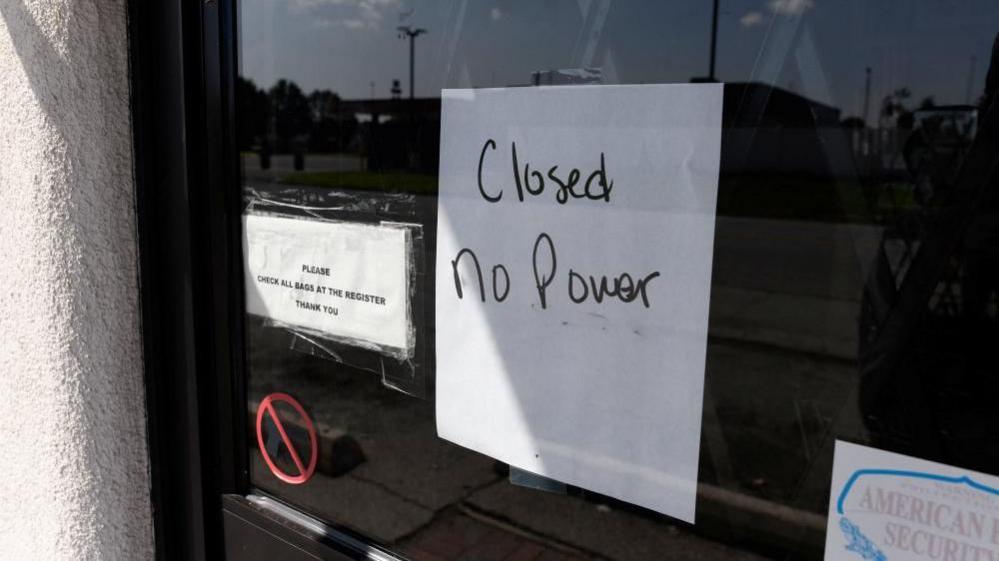 Sign on glass door of business that reads "Closed No Power" 