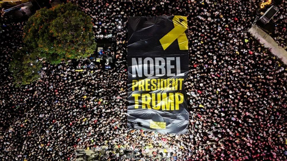 banner at tel aviv rally calling for a nobel for trump