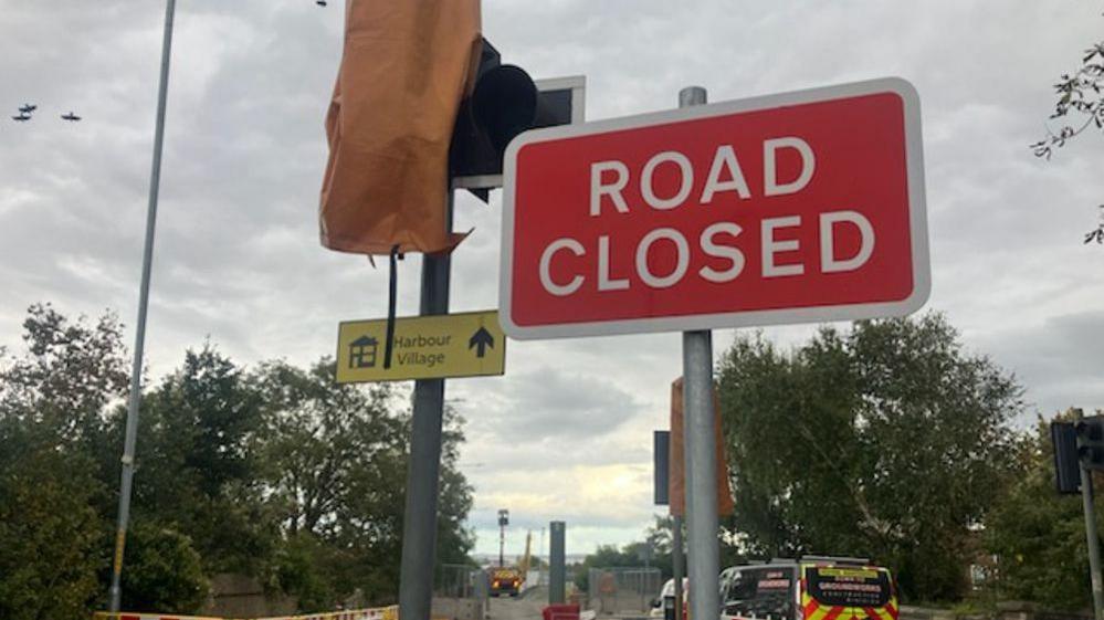 A road closed sign in Stanhope Road, Swanscombe, with a covered up and disused set of traffic lights behind it.