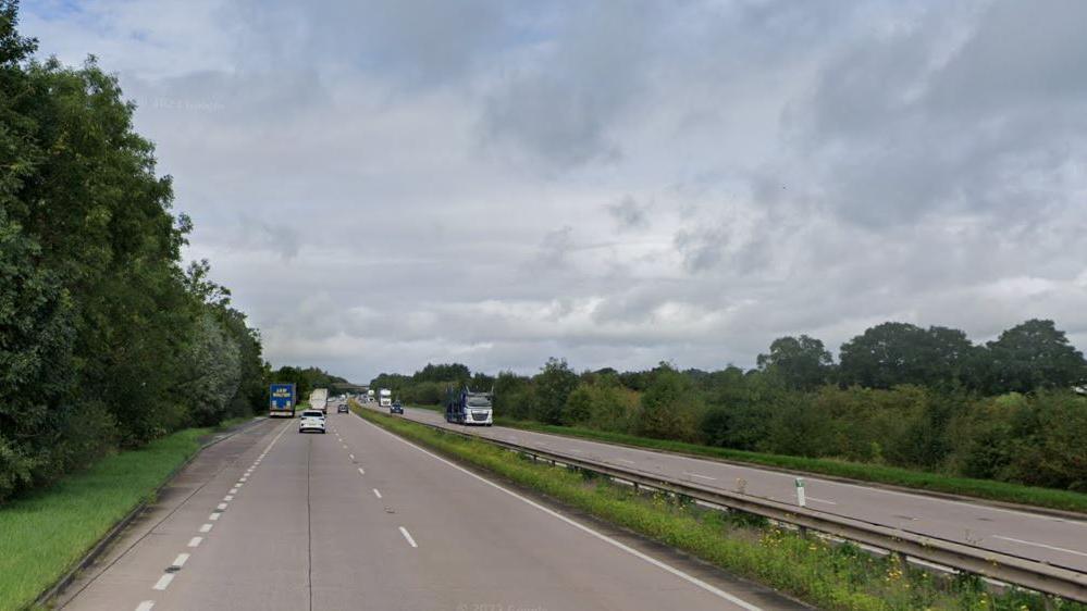 A long stretch of dual carriageway with trees flanking it on either side