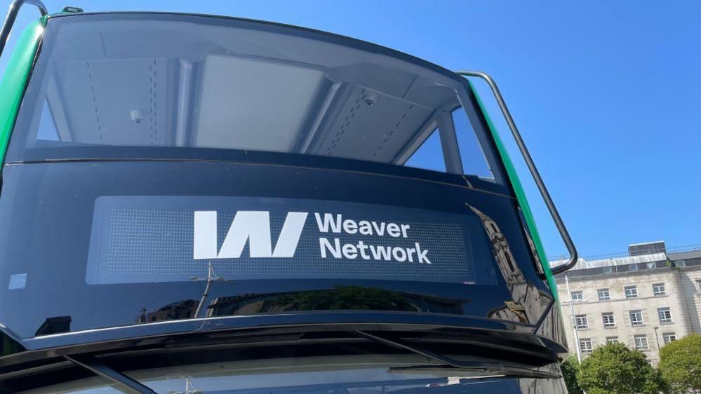 Close-up of a double-decker bus showing the Weaver Network white logo.