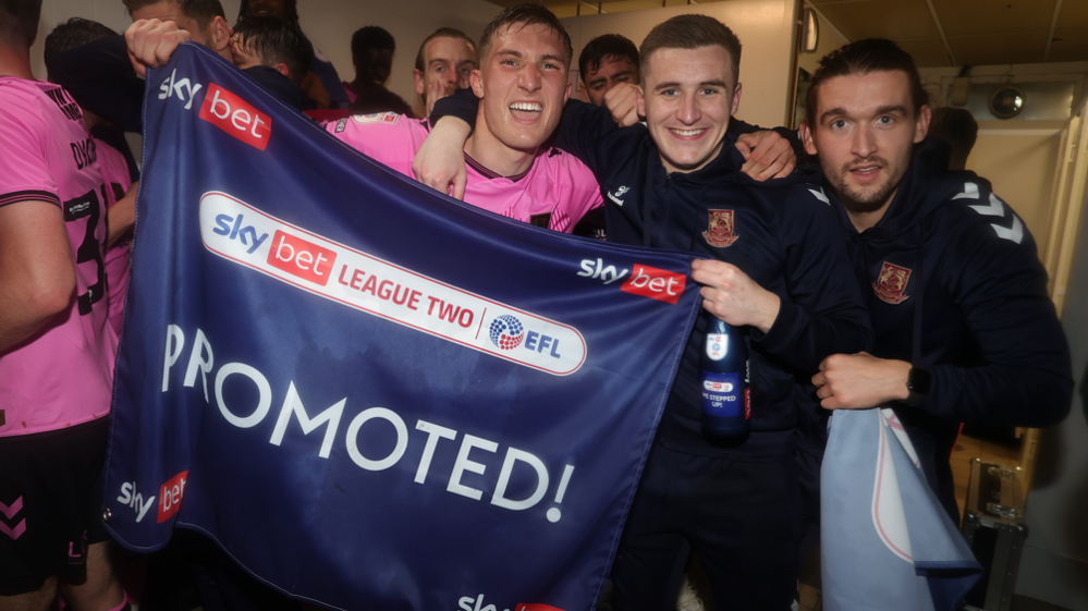 Aaron McGowan (second right) celebrates Northampton Town's promotion to League One in May 2023