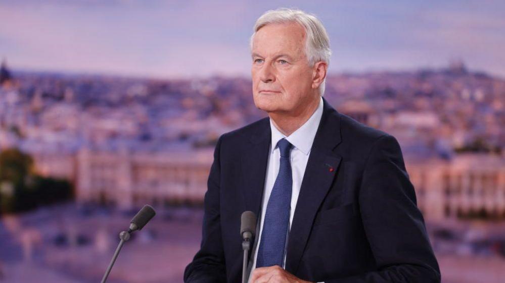 Michel Barnier looks on before the start of the evening news broadcast of French TV channel TF1