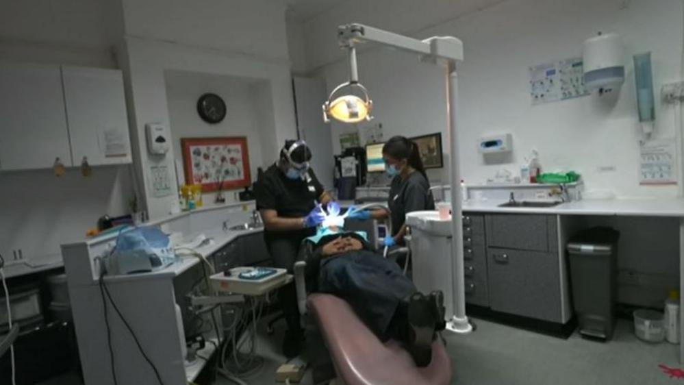 A patient sits in a dentist's chair