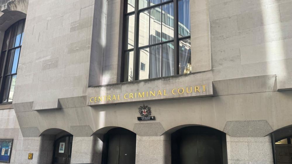 The outside of the Central Criminal Court, commonly known as the Old Bailey in central London. The entrance to the grey building.