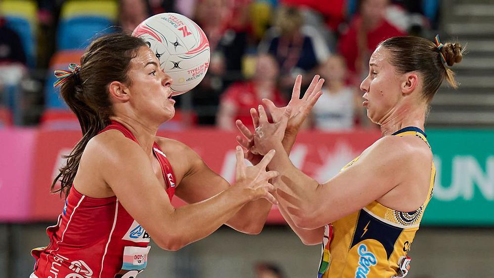 Grace Whyte of the Swifts and Mahalia Cassidy of the Lightning contest the ball during the Super Netball match between NSW Swifts and Sunshine Coast Lightning in May 2026, with Whyte in red kit and Cassidy in largely orange.