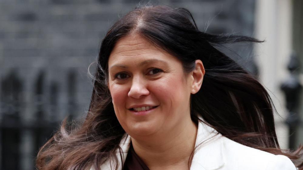 Culture Secretary Lisa Nandy smiles as she looks towards the camera. She has long brown hair and is wearing a white jacket