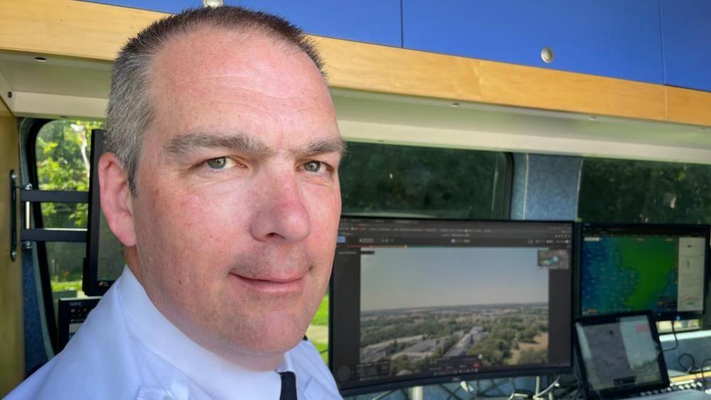 Supt Phill Gray sitting in drone monitor control van