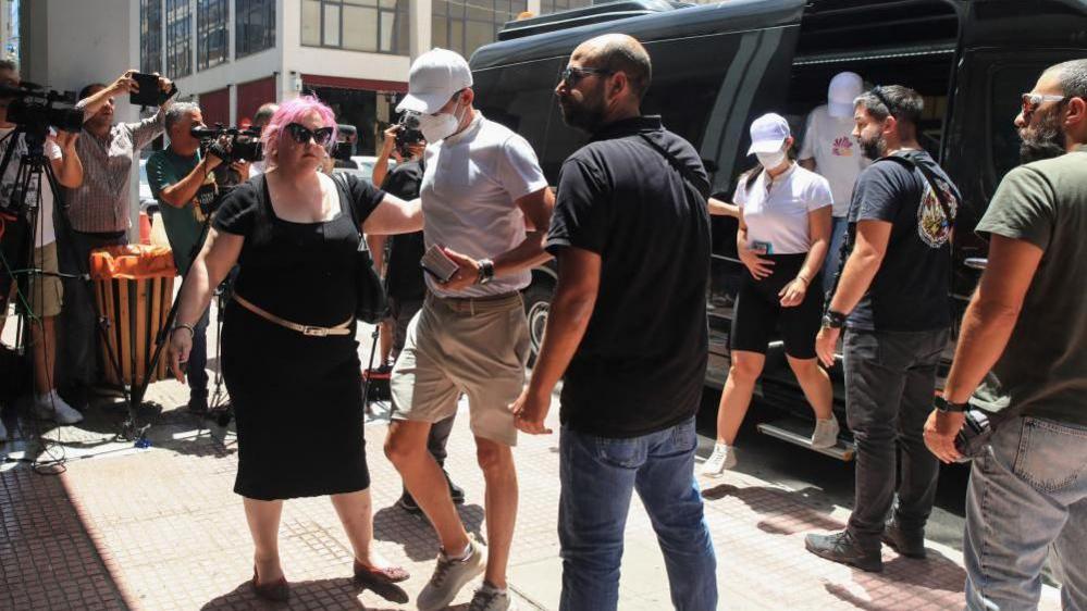 Crew members of a yacht, who allegedly caused a forest fire on the island of Hydra after launching fireworks from the vessel, are transferred to the prosecutor's office at the courthouse of Piraeus, Greece, June 23, 2024