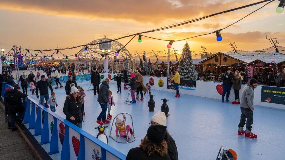 Families wearing winter clothing enjoy themselves on the skating rink at the Christmas by the Sea festival in Blackpool.