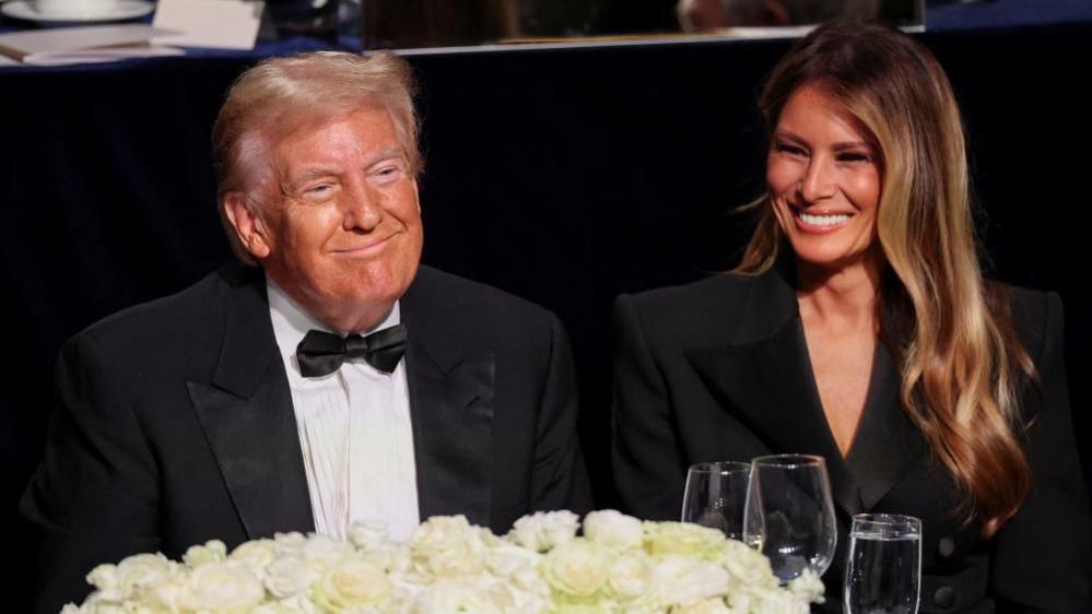 Donald and Melania Trump smile at a charity event