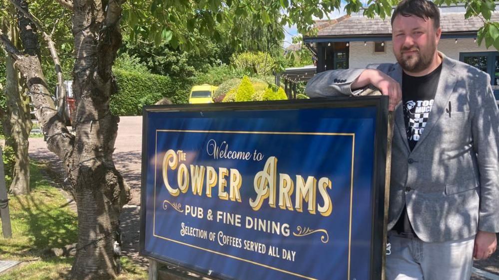 Dan Vine standing next to pub sign