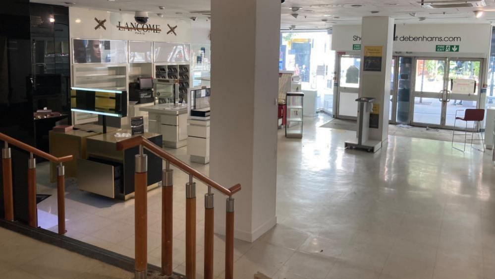 The inside of the former Debenhams store in Bedford, that have showing an old Lancome stand and stairs leading down to doors