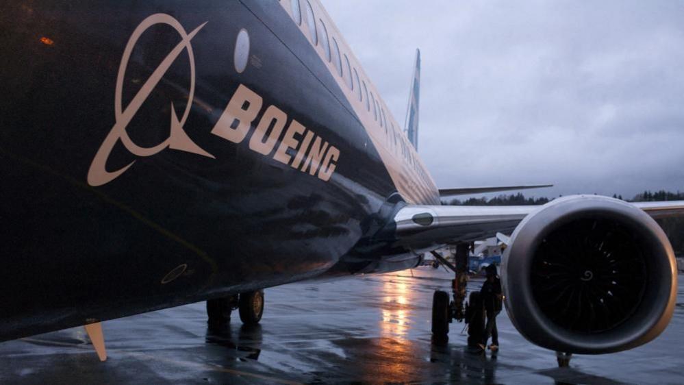 A Boeing 737 Max aircraft is parking outside of an airplane hangar