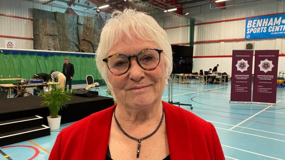 Danielle Stone with light-coloured hair and red top in a sports hall