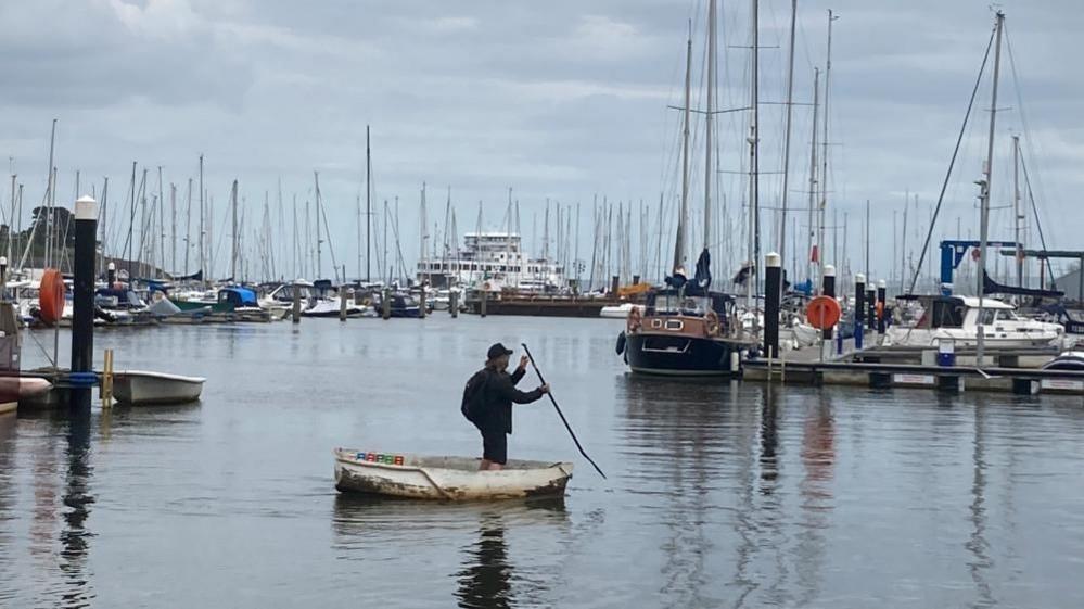 Man in boat off Lymington quay