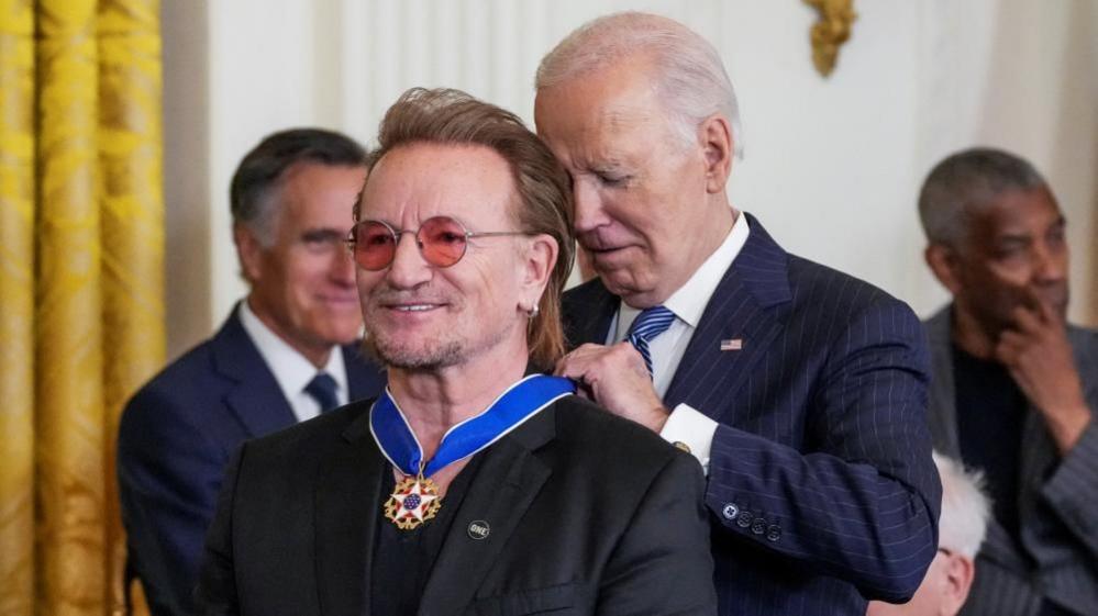 US President Joe Biden presents the Presidential Medal of Freedom to Bono in the East Room of the White House on 4 January 2025