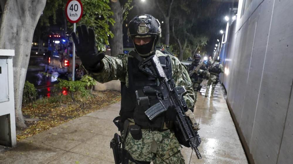 A Mexican soldier holds out his hand in a "stop" gesture as military forces guard the headquarters of the Specialised Prosecutor's Office for Organised Crime (Femdo) in Mexico City, Mexico, 22 November 2023