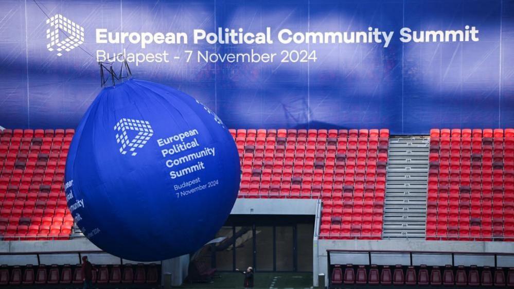 People put up a balloon sign at the European Political Community Summit venue, the Puskas Arena, in Budapest, Hungary, 7 November 2024