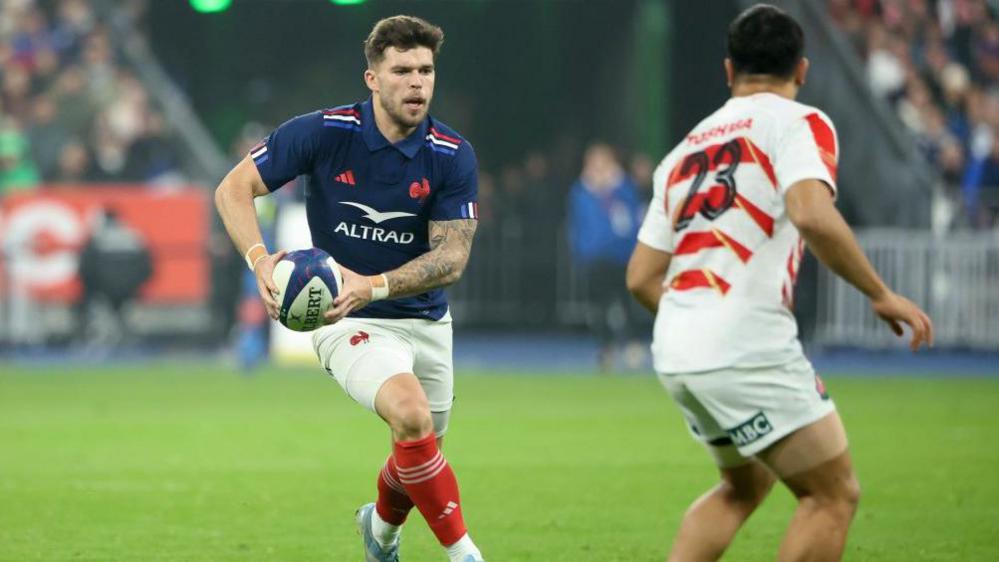 Matthieu Jalibert runs at the Japan defence