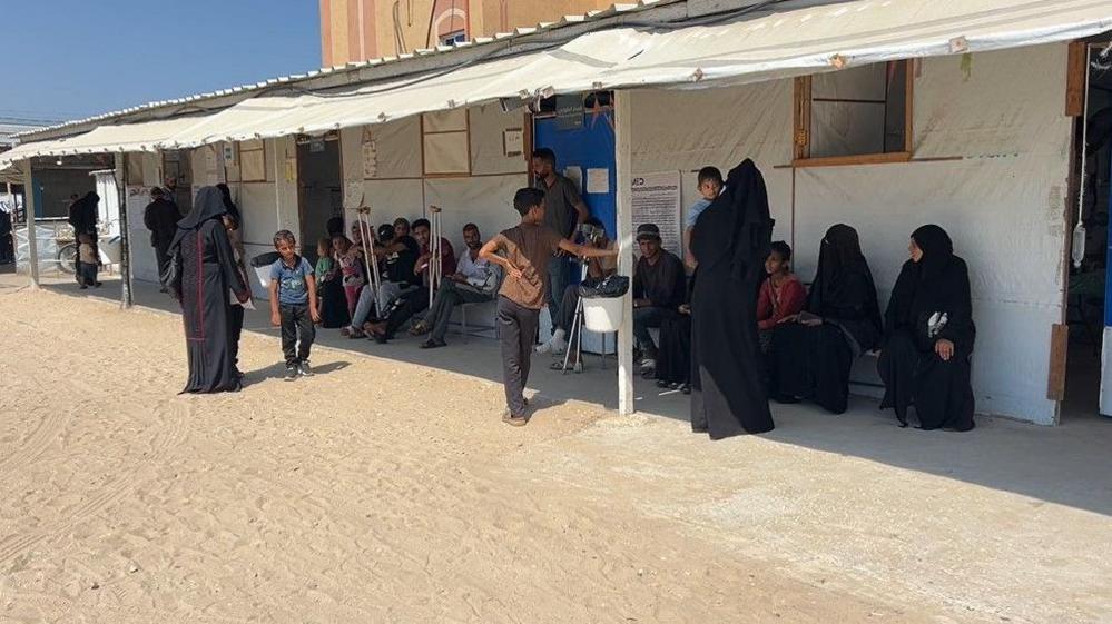 Patients sit outside the UK-Med field hospital in al-Mawasi, southern Gaza