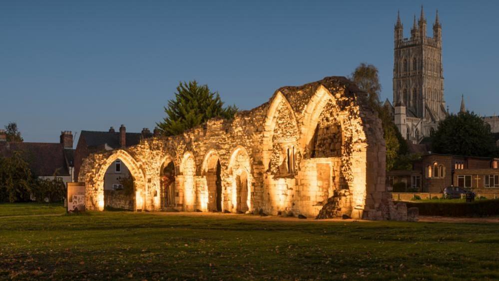 The ruined walls of priory being lit up at night