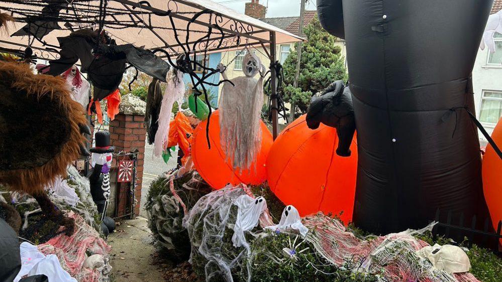 The short garden path has decorations lined all up the sides, the bushes covered with cobwebs, ghosts and skulls, a gazebo keeps some of it dry and also acts as a way to hand more - bats, spiders and ghouls.