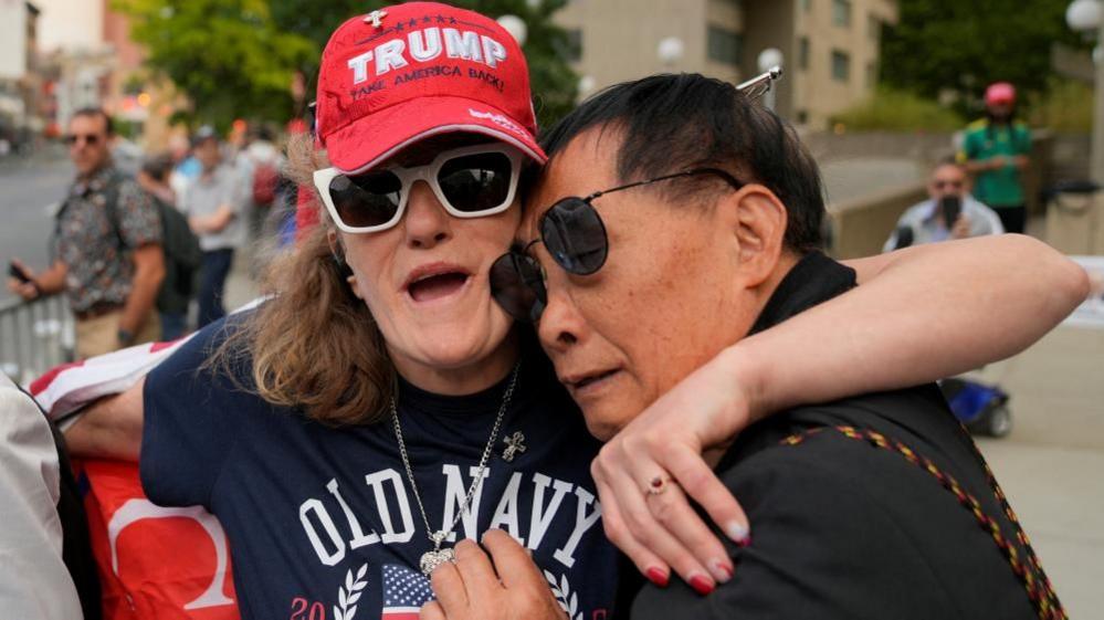 A man and woman embrace outside court after Trump's verdict was announced