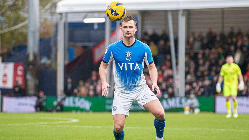 Callum Connolly prepares to head the ball for Stockport County.