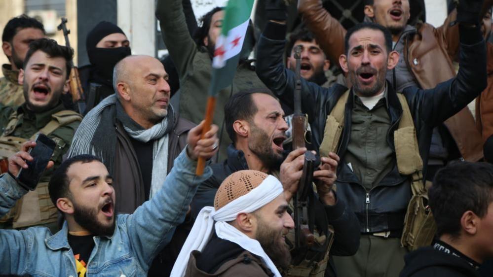 Rebel forces celebrate in Damascus, Syria after the fall of the Bashar al-Assad regime. 