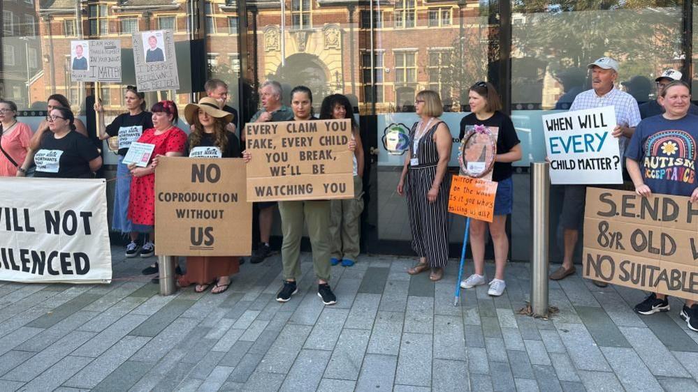 Group of parents with SEND slogans on placards