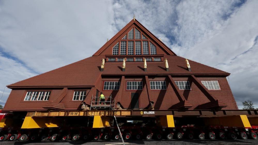 Kiruna's historic wooden church sits on a wheeled transportation unit before being moved to a new site in Kiruna, Sweden