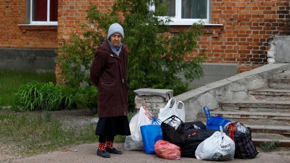 Vovchansk resident Zoia, 72-year-old, waits for assistance during evacuation to Kharkiv due to Russian military strikes, amid Russia's attack on Ukraine, near the frontline town of Vovchansk, in Kharkiv region, Ukraine May 14, 2024