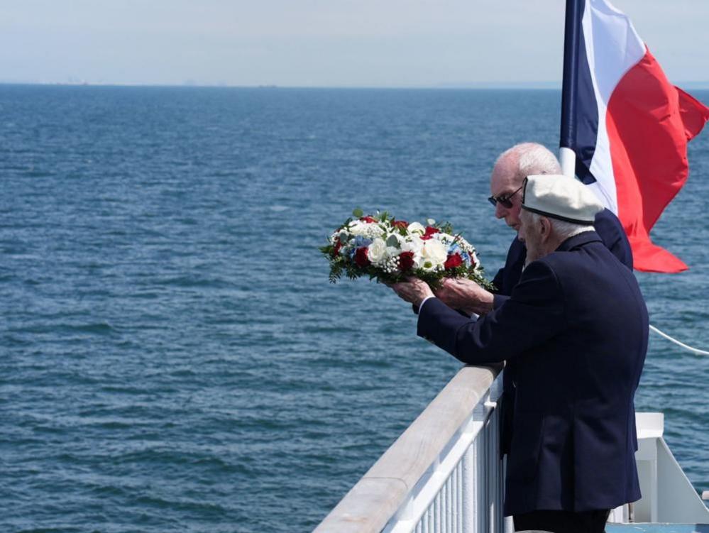 D-Day veterans Harry Birdsall, 98, and Alec Penstone (front), 98, throw a wreath into the sea 